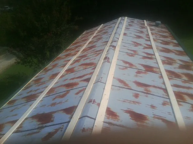 Rusted metal roof panels with new wood purlins before replacement — Storm Damage Roof Repair in Temple by Roofing Brothers