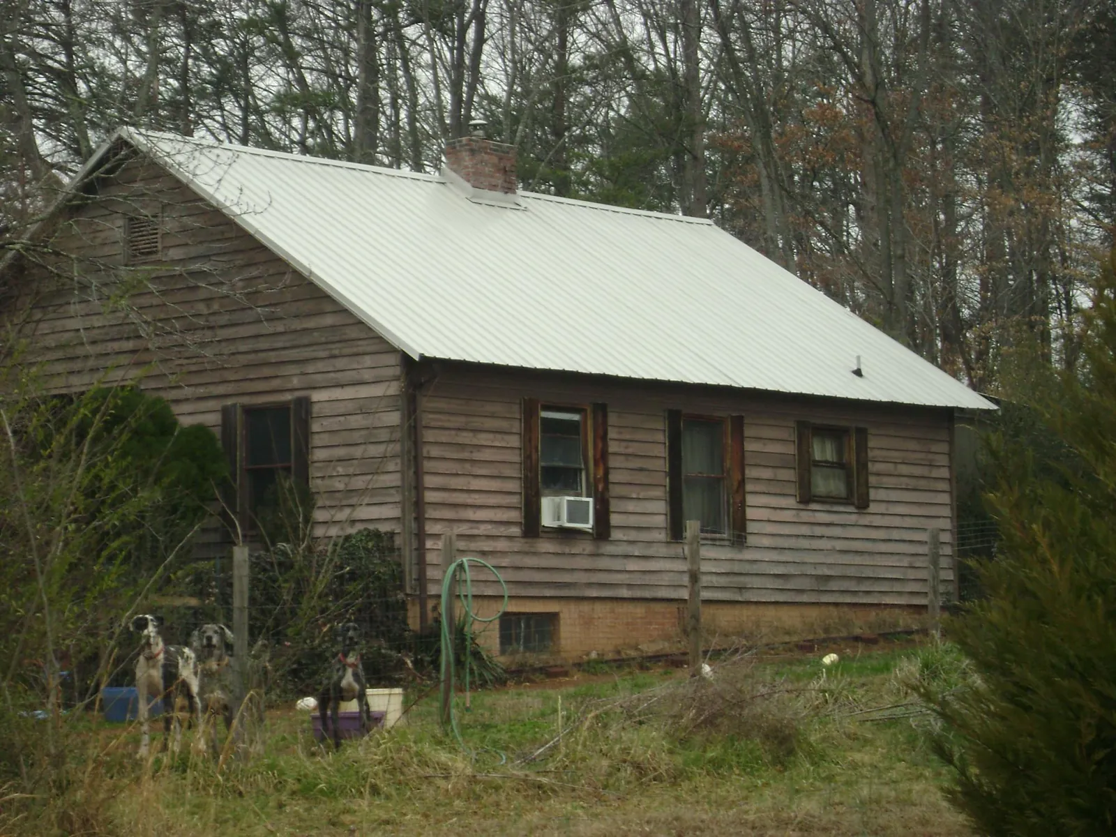 White metal roof on an old wood sided farmhouse, from a Metal Roof Installation job in Temple